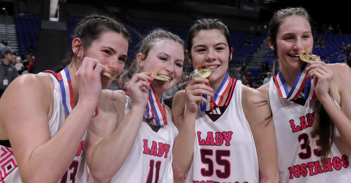 Ruthie Mein (13), Kate Lindsey (11), Kara Nixon (55), and McKenna Wise (33) display their state championship medals after the Martins Mill Lady Mustangs captured the Class 2A State Championship Game in thrilling fashion with a last-second 44-42 victory over Nocona.
